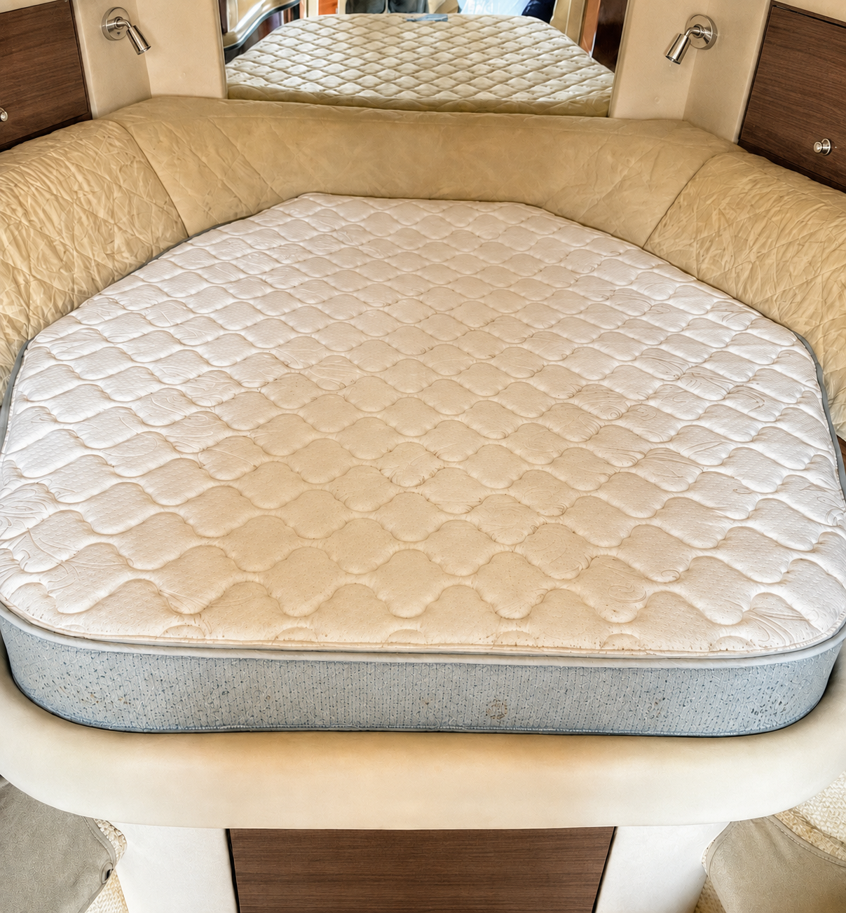 Light mildew spots the blue side panel and edge of a mattress in a yacht cabin.