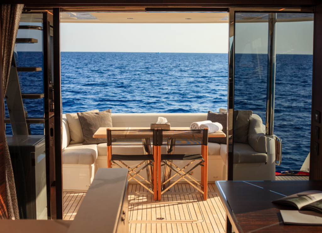 Cool, shaded yacht interior with boat air conditioning overlooking the ocean on a hot summer day.