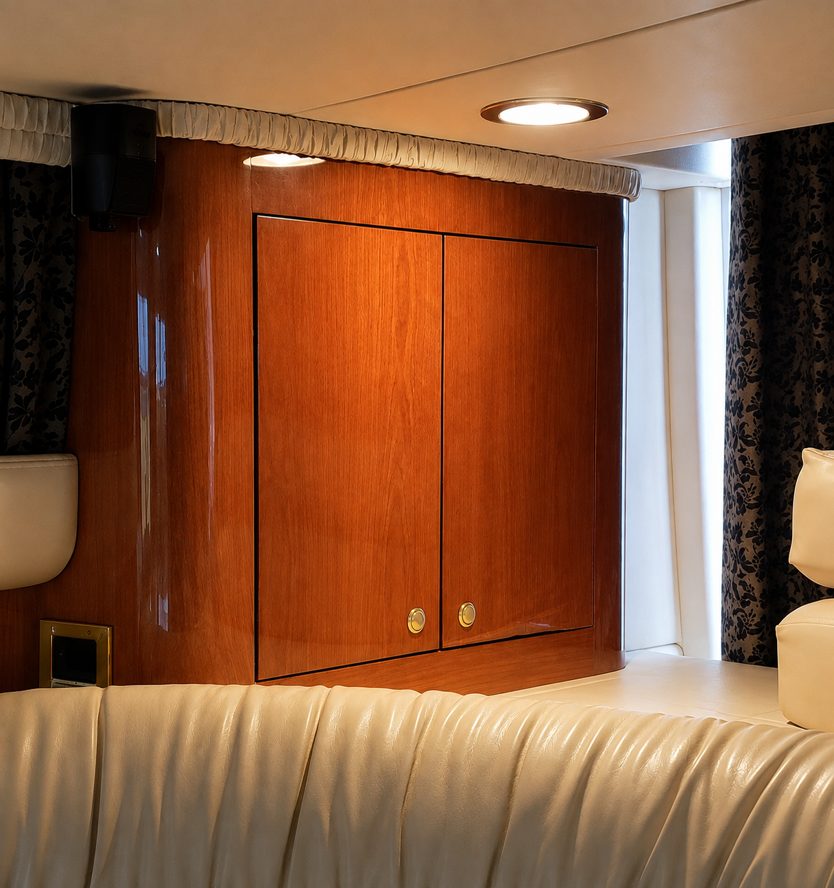 Mild wood veneer delamination along the lower edge of cabinetry in a yacht cabin.